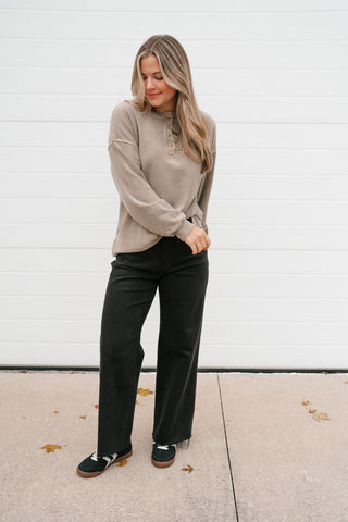 Full-length view of the mocha waffle knit thermal top styled with black trousers