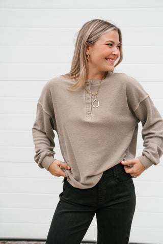 Smiling model in the mocha waffle knit henley showing the drop shoulders and button neckline