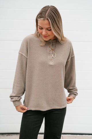 Waist-up view of the women's mocha thermal henley top with ribbed cuffs