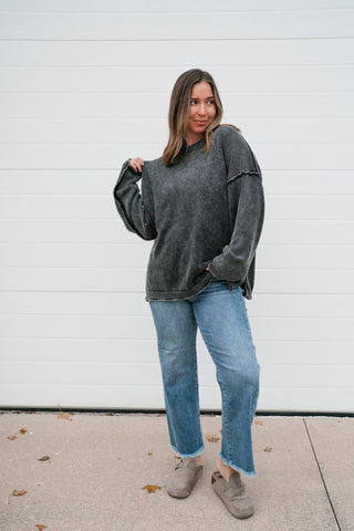 Woman wearing the Ready to Go oversized charcoal mineral-wash knit sweater with light wash jeans and clogs