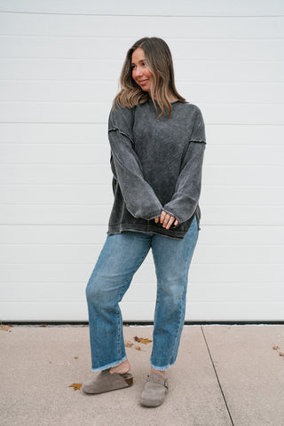 Full-length front view of the charcoal vintage-wash knit sweater styled with cropped jeans and clogs