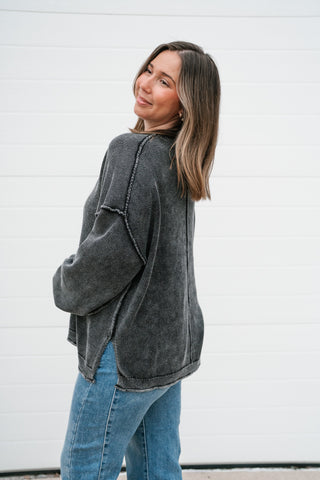 Side view of the charcoal oversized knit sweater showing the side slit and relaxed length