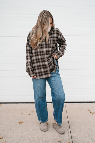 Woman wearing the Maren chocolate brown plaid button down long sleeve top with wide leg jeans