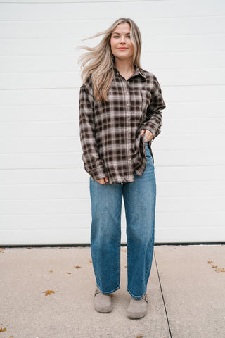 Full-length view of the brown and cream plaid button down shirt styled with jeans and suede clogs
