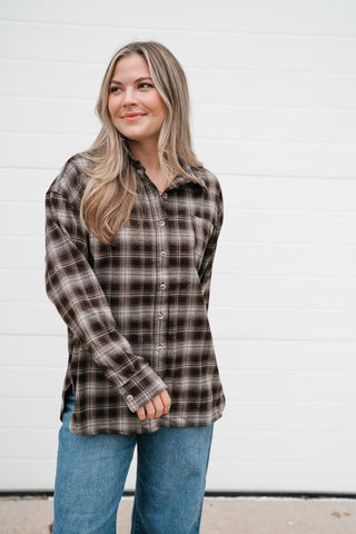 Front view of the chocolate plaid button up top worn with jeans
