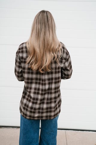 Back view of the oversized chocolate brown plaid button down shirt