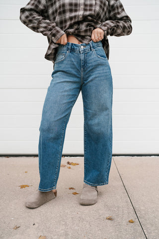 Medium wash slouchy cropped barrel jeans showing the high rise and relaxed fit