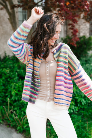 Woman wearing a colorful striped sweater in an outdoor setting