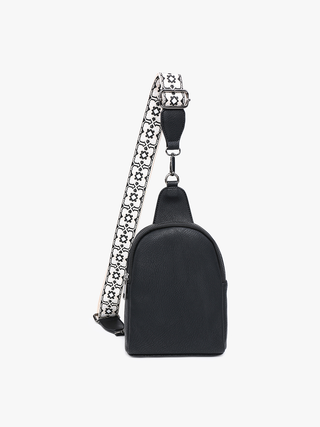 Black pebbled leather sling backpack purse with patterned adjustable crossbody strap.
